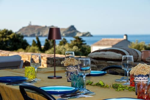 Table élégante en terrasse à Villa Camille avec vue mer sur la baie de Centuri et les îles