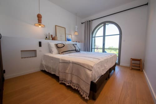 Chambre lumineuse à la Villa Camille de La Conciergerie du Cap Corse avec vue mer par porte voûtée, parquets et
