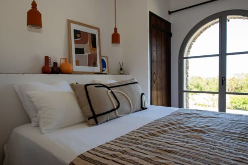 Chambre lumineuse à la Villa Camille à Centuri avec vue mer, lit moderne, luminaires en terre cuite et fenêtre cintrée