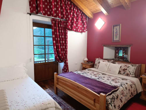 Camera Orsola a La Tour B&B a Oyace con letti gemelli, pareti color borgogna, tende con motivi di fiocchi di neve e vista sulle montagne
