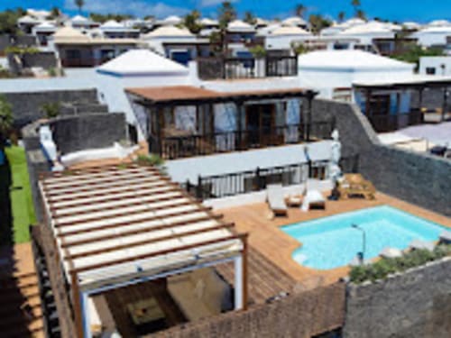 Vista aérea de Villa Cavendish con piscina, terraza y casas encaladas en Playa Blanca
