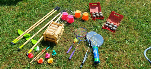 Équipements de sports extérieurs au Chalet Les Arcosses : raquettes de badminton, maillets de croquet, balles et jeux de pétanque sur l'herbe