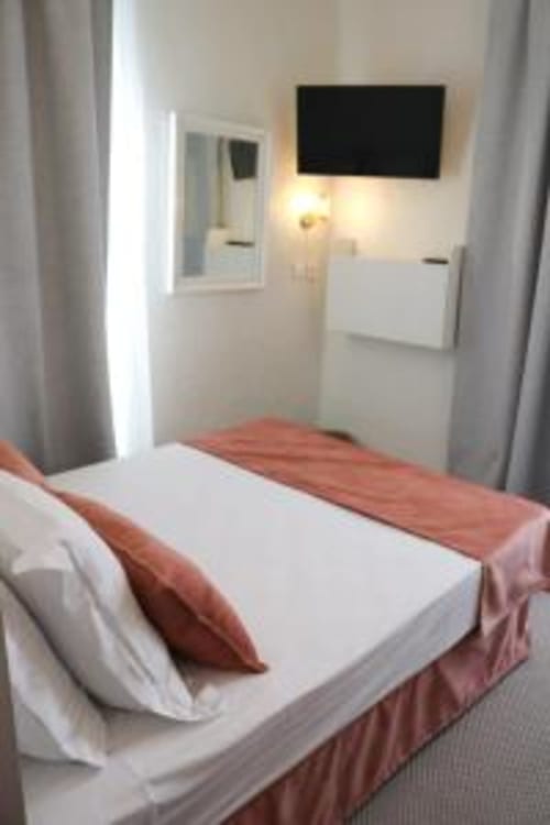 Chambre double moderne à l'Hôtel Villa Roseraie à Vence avec TV écran plat, literie blanche et vue sur jardin