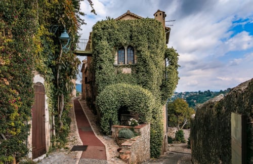Ivy-covered stone buildings on a charming cobblestone street in Vence, France at Hotel Villa Roseraie
