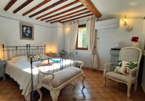 Chambre lavande à La Bergerie Du Moulin, gîte à Taradeau en France, avec lit en métal, poutres apparentes et équipements modernes