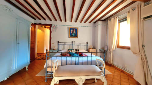 Lavender room at La Bergerie Du Moulin B&B in Taradeau with metal bed frame, wooden beams, and terracotta floors