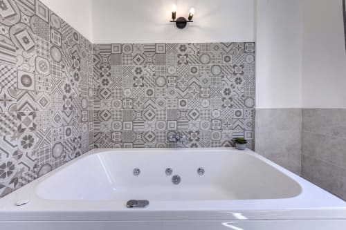 Luxurious jacuzzi bathtub with patterned tile walls at Palazzo Belvedere hotel in Chianciano Terme, Italy