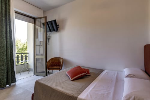 Modern double bedroom at Palazzo Belvedere with balcony view, flat-screen TV, and elegant furnishings in Chianciano Terme