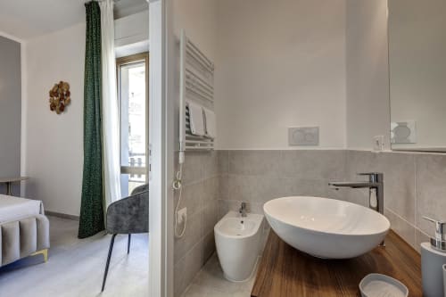 Modern bathroom at Palazzo Belvedere with oval white sink, bidet, and heated towel rack in Chianciano Terme