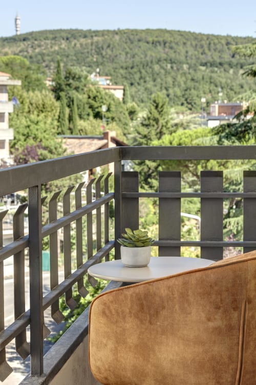 Balcony seating at Palazzo Belvedere in Chianciano Terme with forest views and potted succulent plant