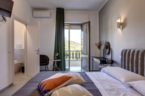 Spacious double room with balcony at Palazzo Belvedere in Chianciano Terme, featuring modern furnishings and landmark views