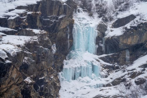 Cascata ghiacciata che scende fra le rocce in paesaggio invernale vicino a La Tour B&B, Oyace Italia