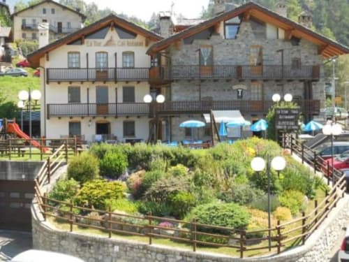 L'hotel La Tour a Oyace con architettura alpina, terrazze, giardini paesaggistici e ombrelloni blu