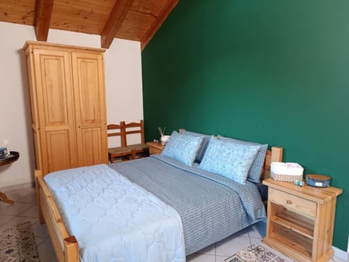 Camera rustica alla La Tour B&B di Oyace con mobili in legno, parete verde e biancheria blu