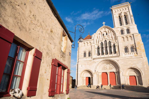 Medieval church with cream stone facade and red doors in Sermizelles, France near Les Gîtes de l'Impériale B&B