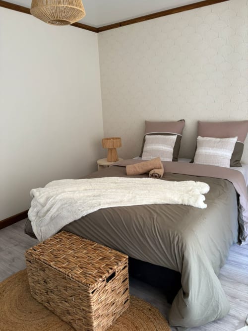 Chambre moderne de la villa Au pied des Sources avec vue sur les montagnes, tons neutres et accents tissés