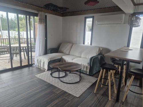 Salon moderne de la villa Au pied des Sources à Cilaos avec vue montagne, mobilier confortable et design contemporain