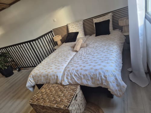 Chambre élégante de la villa moderne Au pied des Sources à Cilaos avec vue montagne, literie à motifs, oreillers noirs