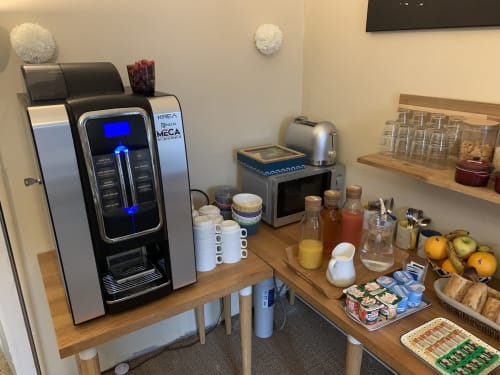 Station à café moderne à l'Hôtel Maison Richet avec machine à espresso, boissons et petit-déjeuner aux Sables-d'Olonne.