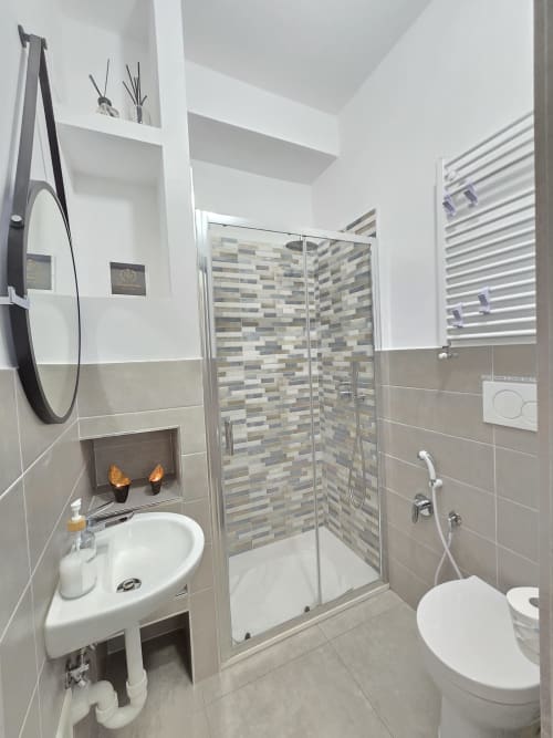 Moderni kupaonica apartmana Raymihome u Torinu s tušem, umivaonom, toaletom i pločicama na zidovima