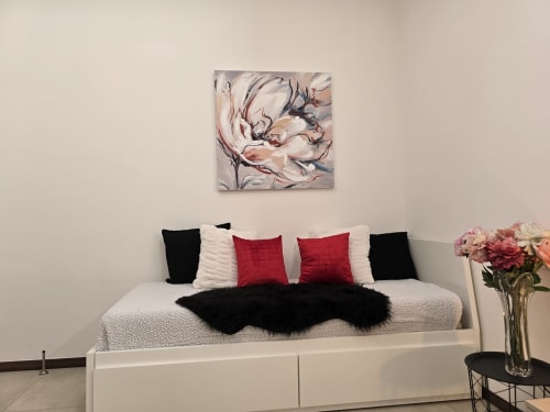 Raymihome apartman u Torinu s bijelim krevetom, crvenim i crnim dekorativnim jastuцima i cvjetnom kunstnom djelom u blagovaoni