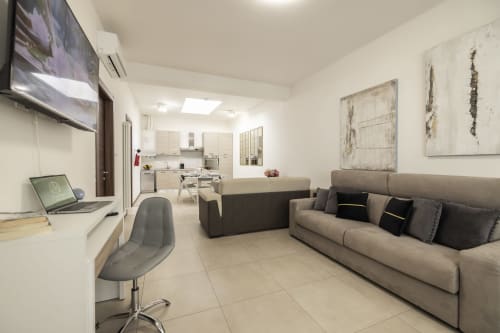Moderni apartman u Torinu s bežom sofom, stol, TV, otvorenom kuhinjom i blagavaonom kod Raymihome