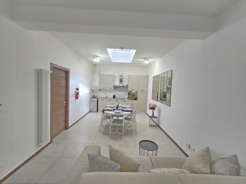Moderna kuhinja i blagovonica apartmana Torino s mjestima za sjedenje, aparatima i svetlosnim otvorom u Raymihome