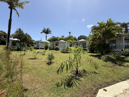 Les bungalows du Domaine de la Glacière entourés de jardins tropicaux et de palmiers à Petit-Bourg, Guadeloupe