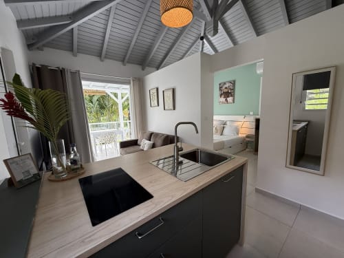 Cuisine et chambre modernes ouvertes au Domaine de la Glacière, Petit Bourg, avec îlot central et vue sur la mer