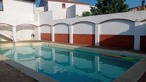 Piscina cubierta en Masia Rural Ca l'Eloi Janet cerca de Barcelona, con paredes blancas y detalles de ladrillo rojo