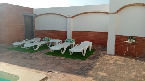 Terraza en la azotea de Masia Rural Ca l'Eloi Janet cerca de Barcelona con tumbonas y detalles de ladrillo