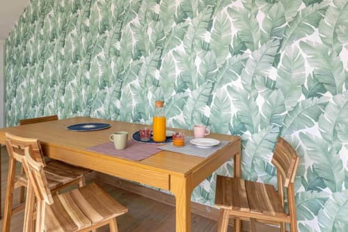 Comedor del hotel Residencia Demar en Godella con mesa de madera, sillas y papel tapiz con motivos botánicos verdes
