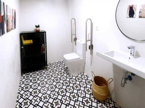 Modern bathroom at Residencia Demar hotel in Godella with geometric floor tiles, white fixtures, and decorative touches