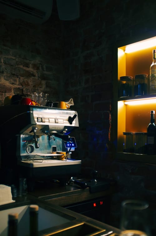 Macchina per espresso professionale a La Tour B&B di Oyace con scaffalature illuminate e bottiglie di vino