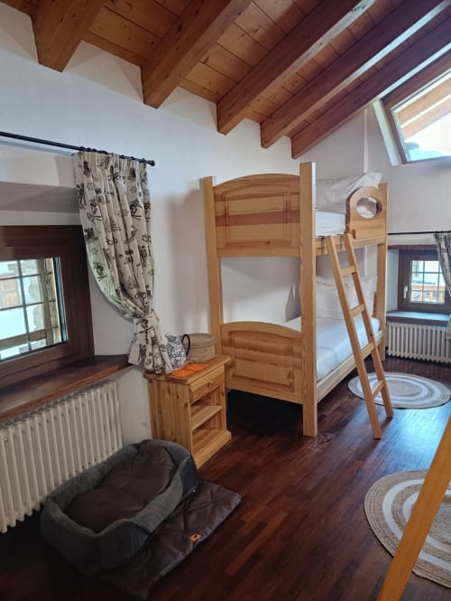 Letti a castello in legno nella camera quadrupla Frederick di La Tour B&B, Oyace, con travi a vista e pavimenti in legno massiccio