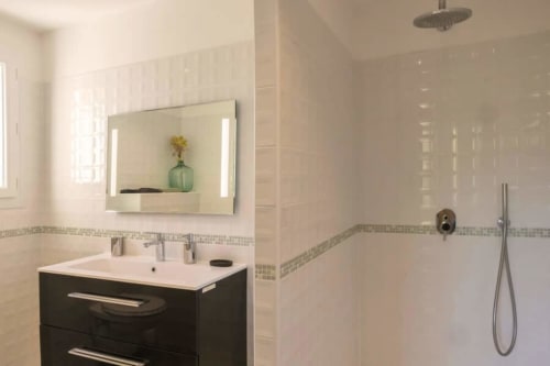 Salle de bain contemporaine avec vasque noire, miroir lumineux, carrelage métro blanc et douche italienne à Villa Odette, Centuri
