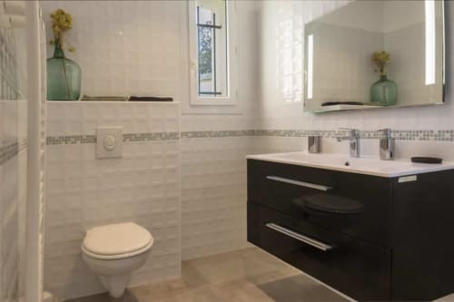 Salle de bain moderne à la Villa Odette de La Conciergerie du Cap Corse : meuble noir, carrelage blanc et douche