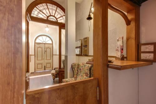Recepción del hotel MoneoHeritage en Salamanca con panelado de madera, arco arquitectónico y decoración tradicional