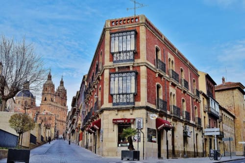 Edificio colonial histórico con fachada de ladrillo rojo en Salamanca España, sede del hotel MoneoHeritage cerca de la catedral