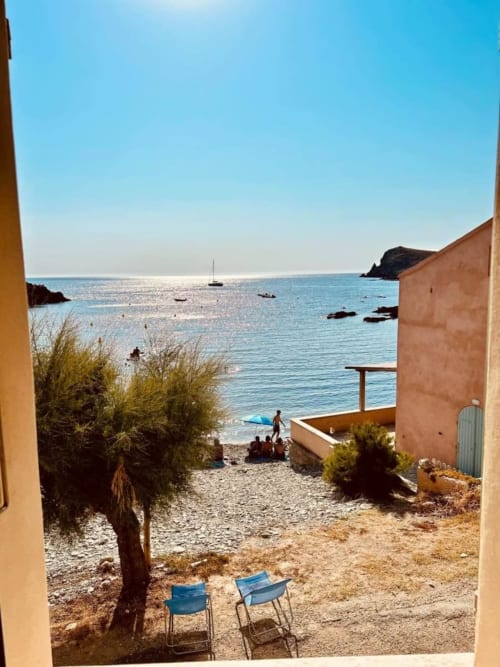 Vue mer de la Villa Casapalmea depuis la terrasse à Centuri, Corse avec chaises longues, voiliers et littoral méditerranéen