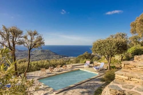 Piscine de la Villa Cathy avec vue sur la mer à Centuri, Corse, transats et arbres méditerranéens