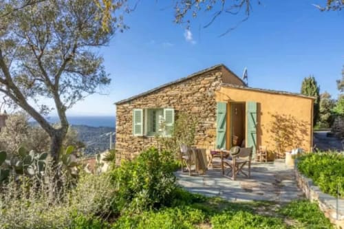 Villa Cathy à Centuri, Corse : villa en pierre aux murs jaunes, vue sur la mer, terrasse avec mobilier de jardin, ambiance méditerranéenne
