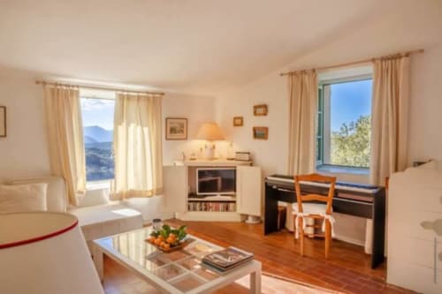 Lumineux séjour villa avec vue mer, parquet, cheminée et mobilier contemporain à Centuri, Corse