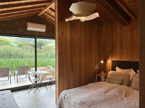 Barn Nest bedroom at Villa Várzea with wooden beams, mountain views, and private balcony overlooking fields