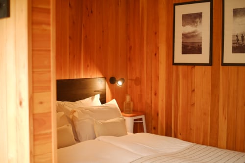 Cozy wooden bedroom at Villa Várzea Barn Nest with white bedding, framed mountain artwork, and warm lighting in Várzea,