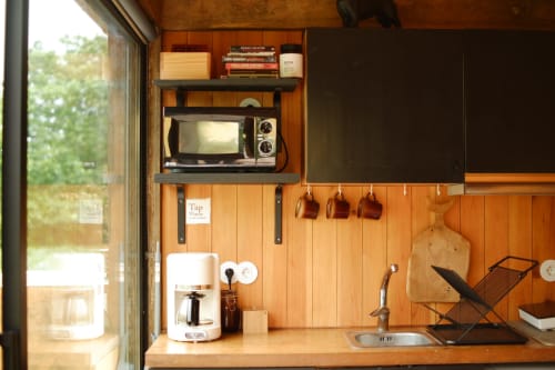 Compact kitchenette in Barn Nest room at Villa Várzea with wooden shelving, microwave, coffee maker, and sink overlooking