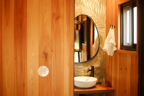 Modern bathroom in Barn Nest room at Villa Várzea with wood walls, round mirror, white vessel sink, and mountain views