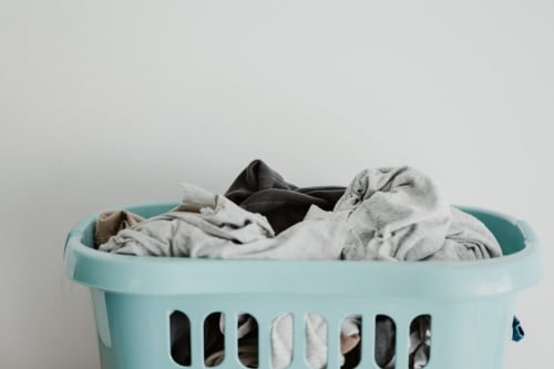Cesto di bucato turchese pieno di vestiti piegati a La Tour bnb di Oyace