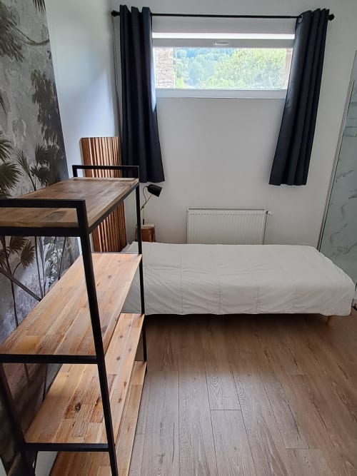 Bright bedroom at Maison de Sophie in Rencurel with wooden desk, single bed, and mountain views through large window