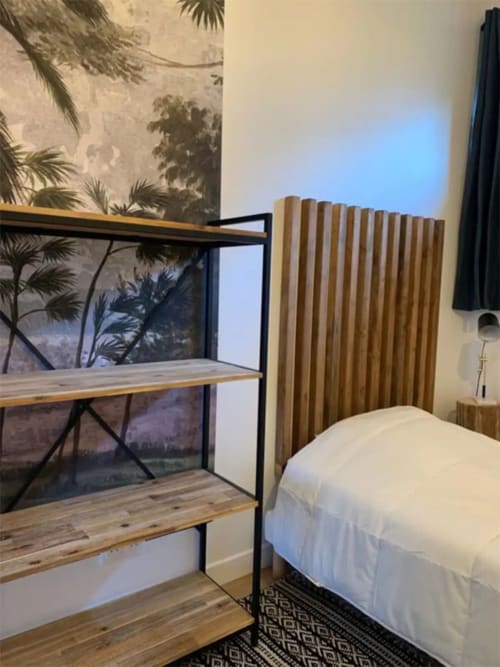 Chambre moderne de la Maison de Sophie B&B à Rencurel avec étagères en bois, lit et art mural tropical